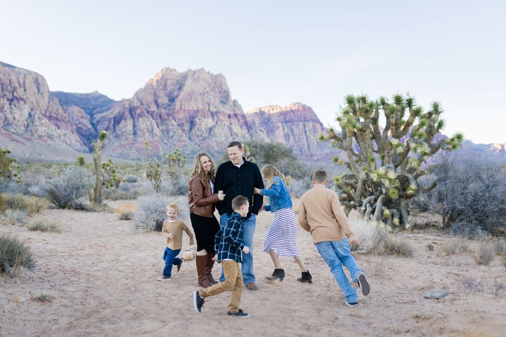 Playful group activity in desert landscape with mountains and Joshua trees.