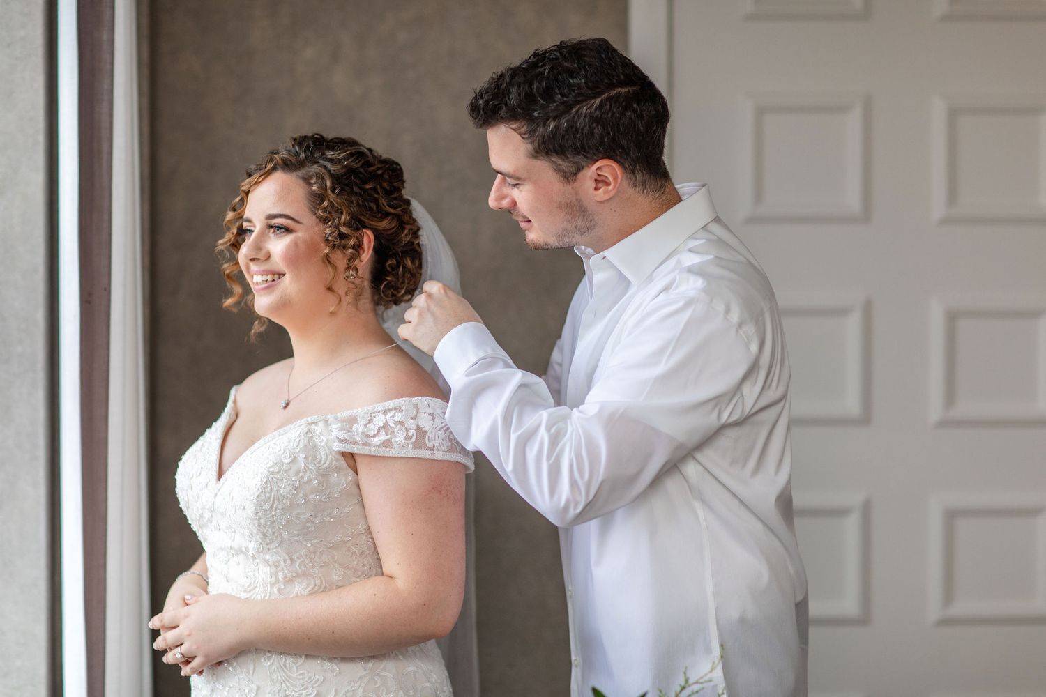 A tender moment captured during wedding preparations by a paneled white door.