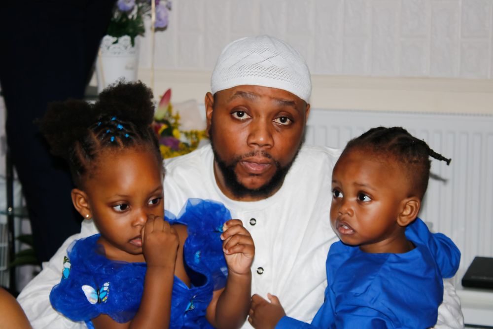 Children wearing blue outfits sit together during a special event celebration.