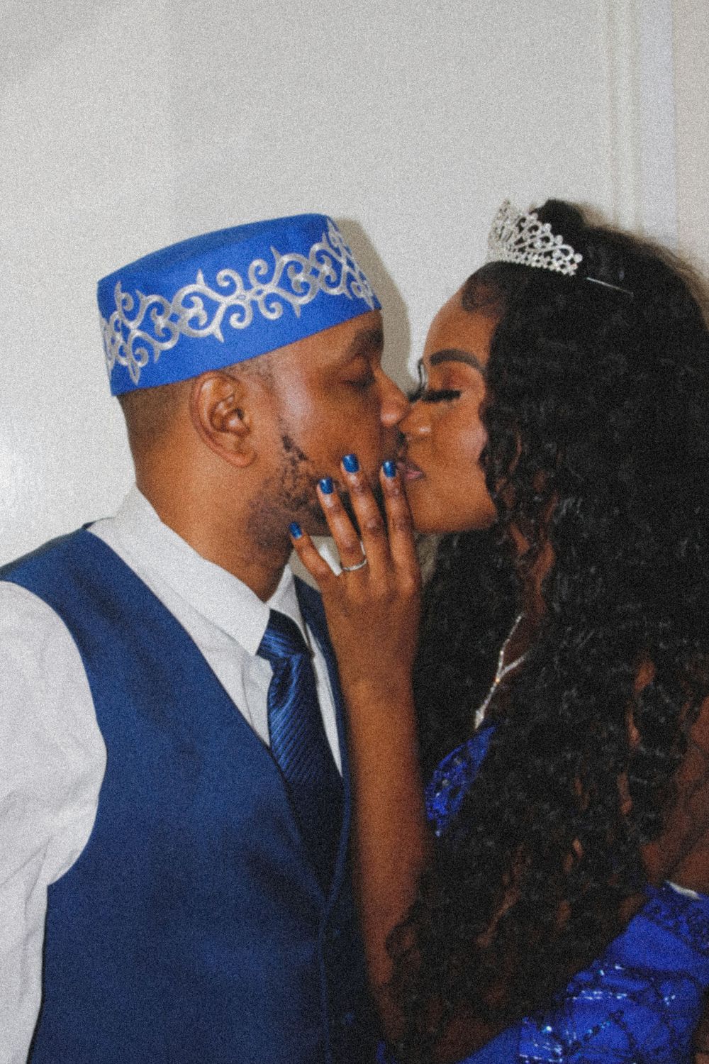 A couple in matching royal blue attire share a romantic moment.