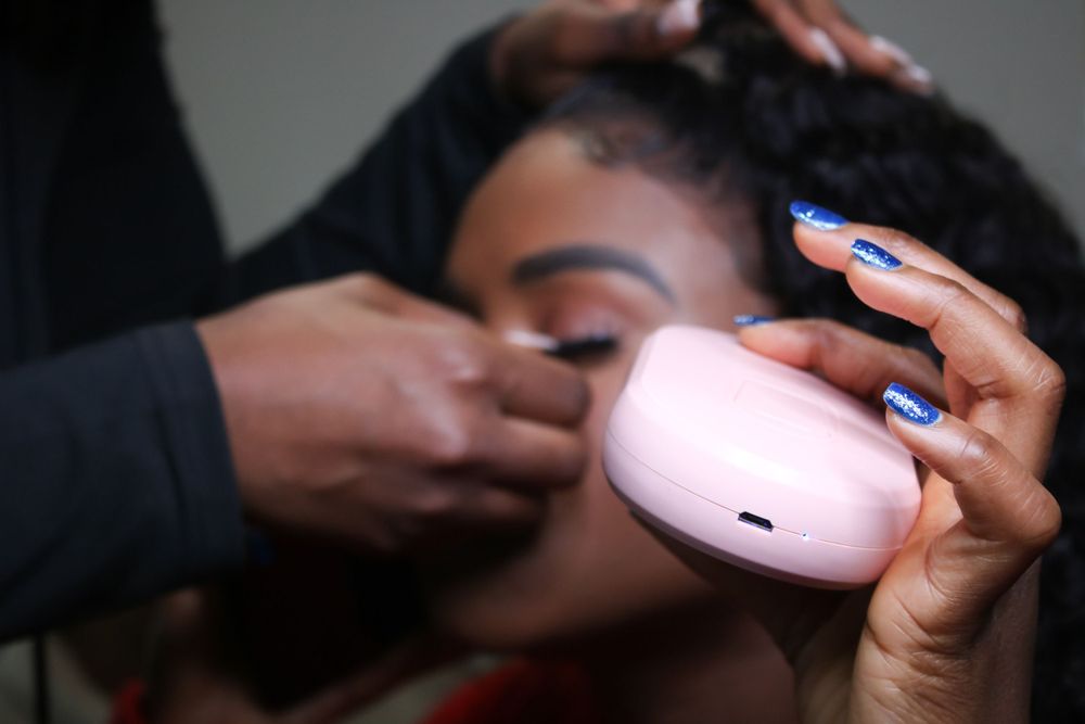 Hands carefully apply makeup during a beauty preparation session.