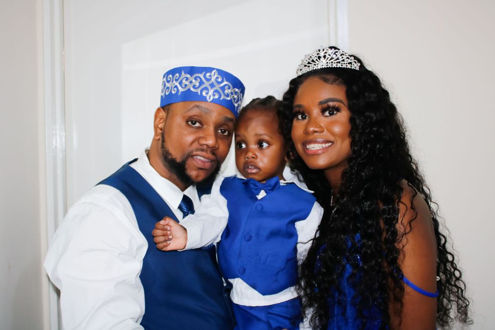 Family portrait with matching blue and white formal outfits and decorative headpieces.