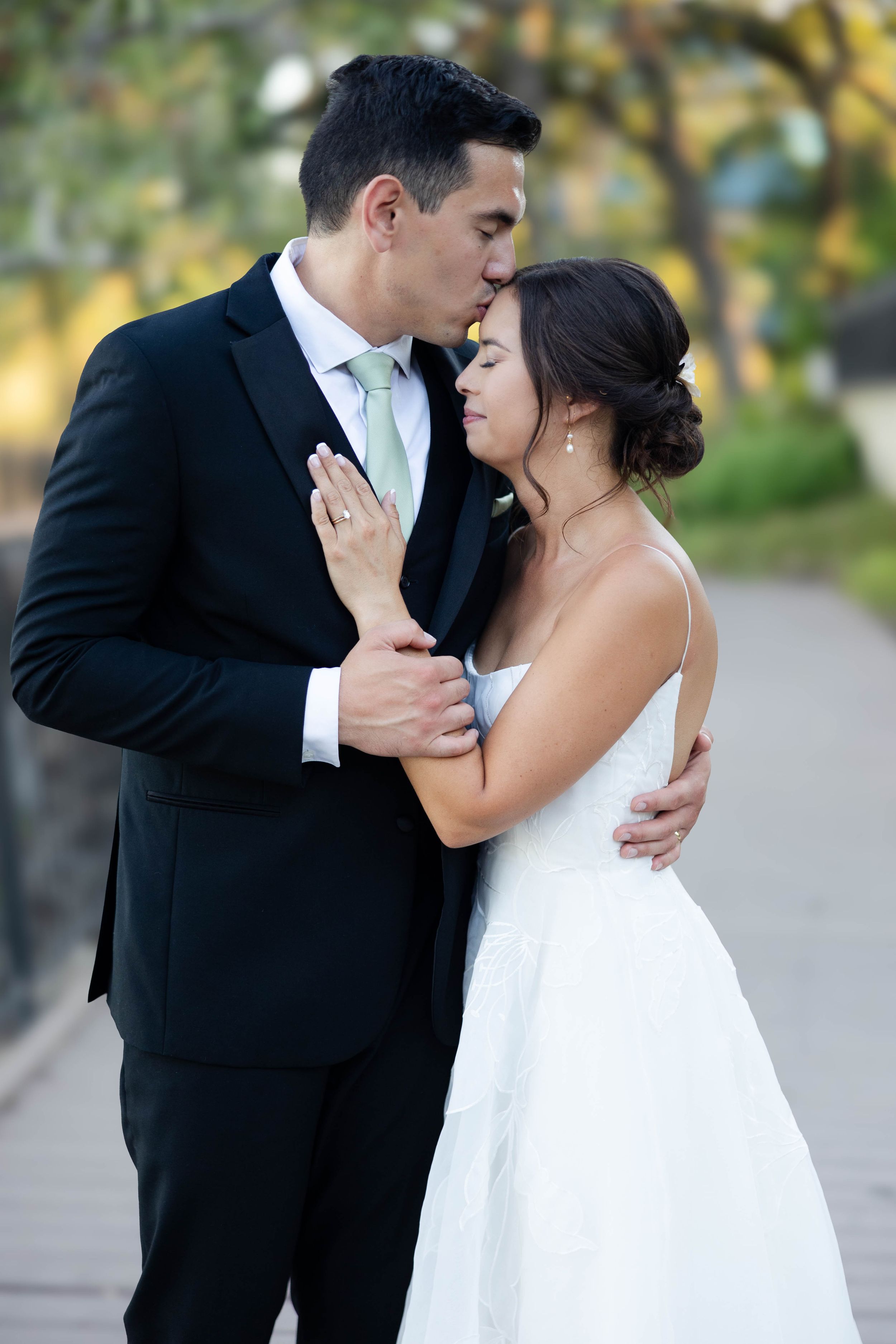 Bride at Lakeside Pavilion in Chico, Ca with trees behind them