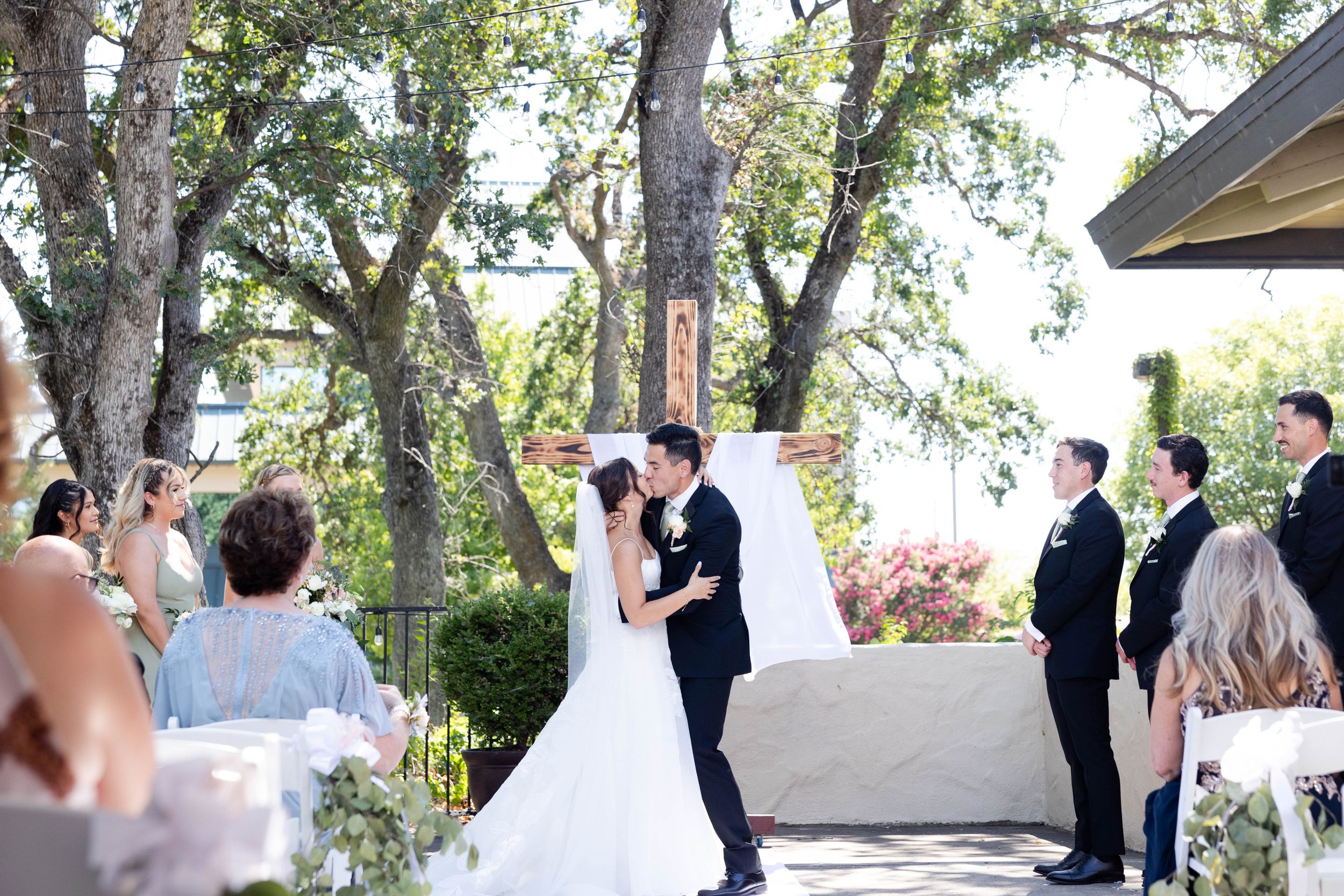 bride and groom first kiss during ceremony at chico, california wedding at lakeside pavilion