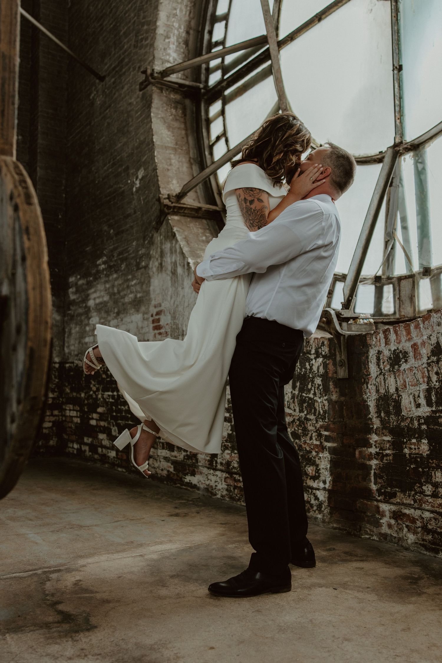 Newlyweds share an intimate moment in golden sunlight on their wedding day.