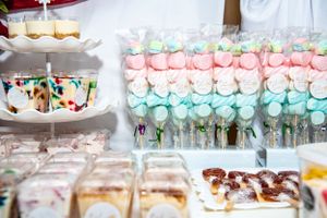Colorful wedding dessert table with pink and blue meringue treats.