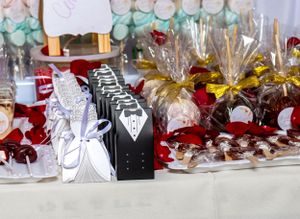 Wedding favors featuring bride and groom themed boxes with red and gold accents.