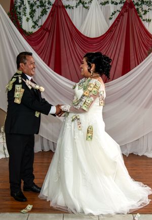Wedding couple performing a money dance with dollar bills during reception.