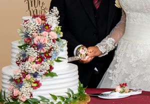 Close-up of wedding cake details showing delicate floral decorations and white frosting.