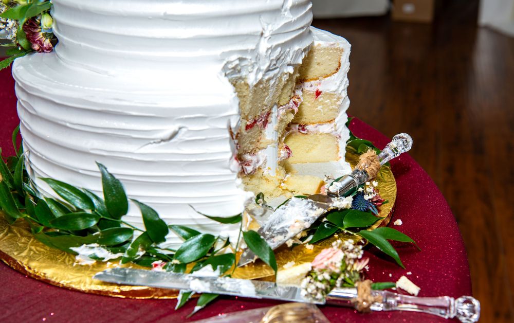 Detailed view of white wedding cake tiers with textured frosting and floral accents.