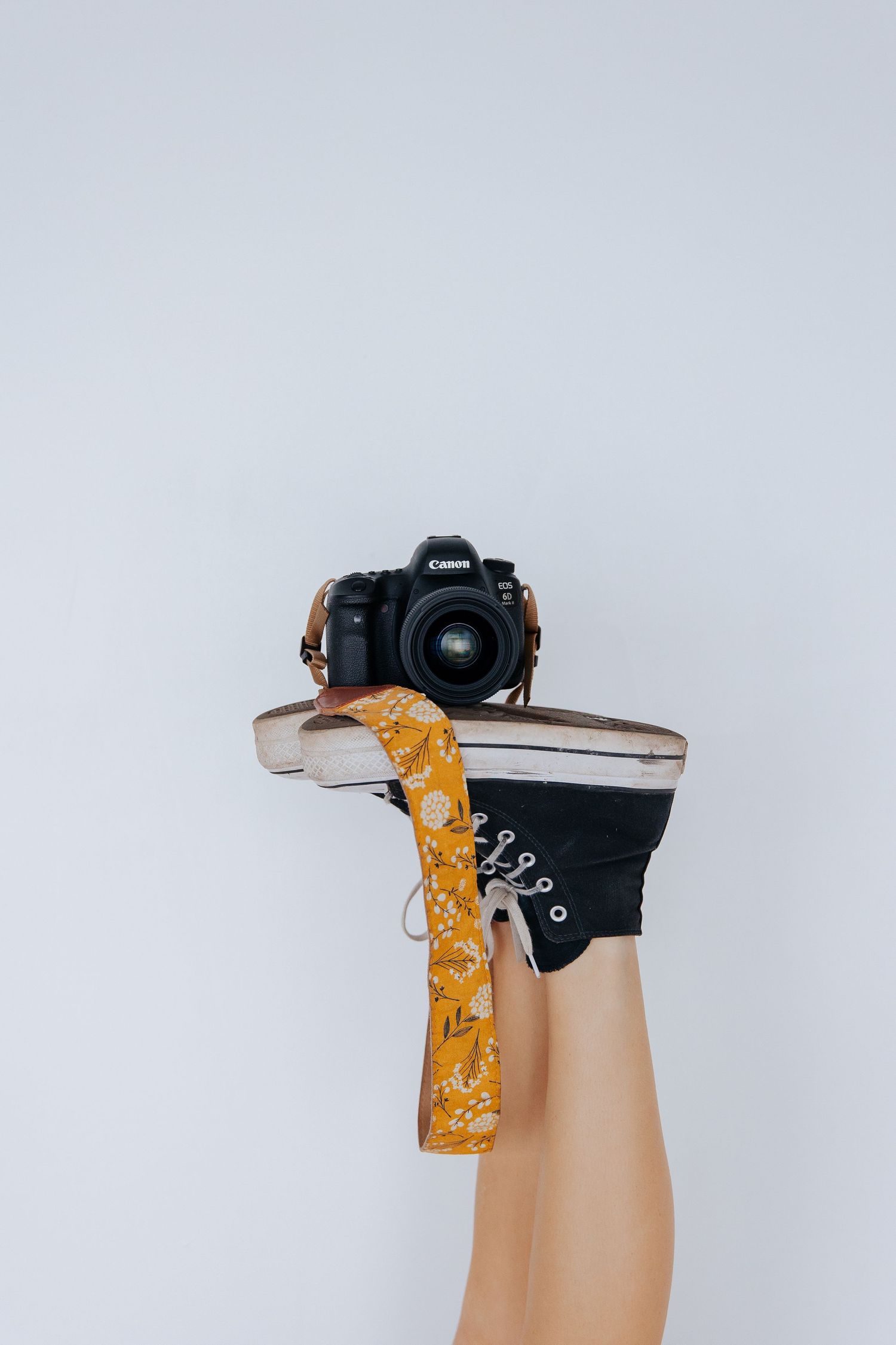 Artistic flat lay composition featuring a camera and yellow fabric against a white background. Alea Joelle Photography