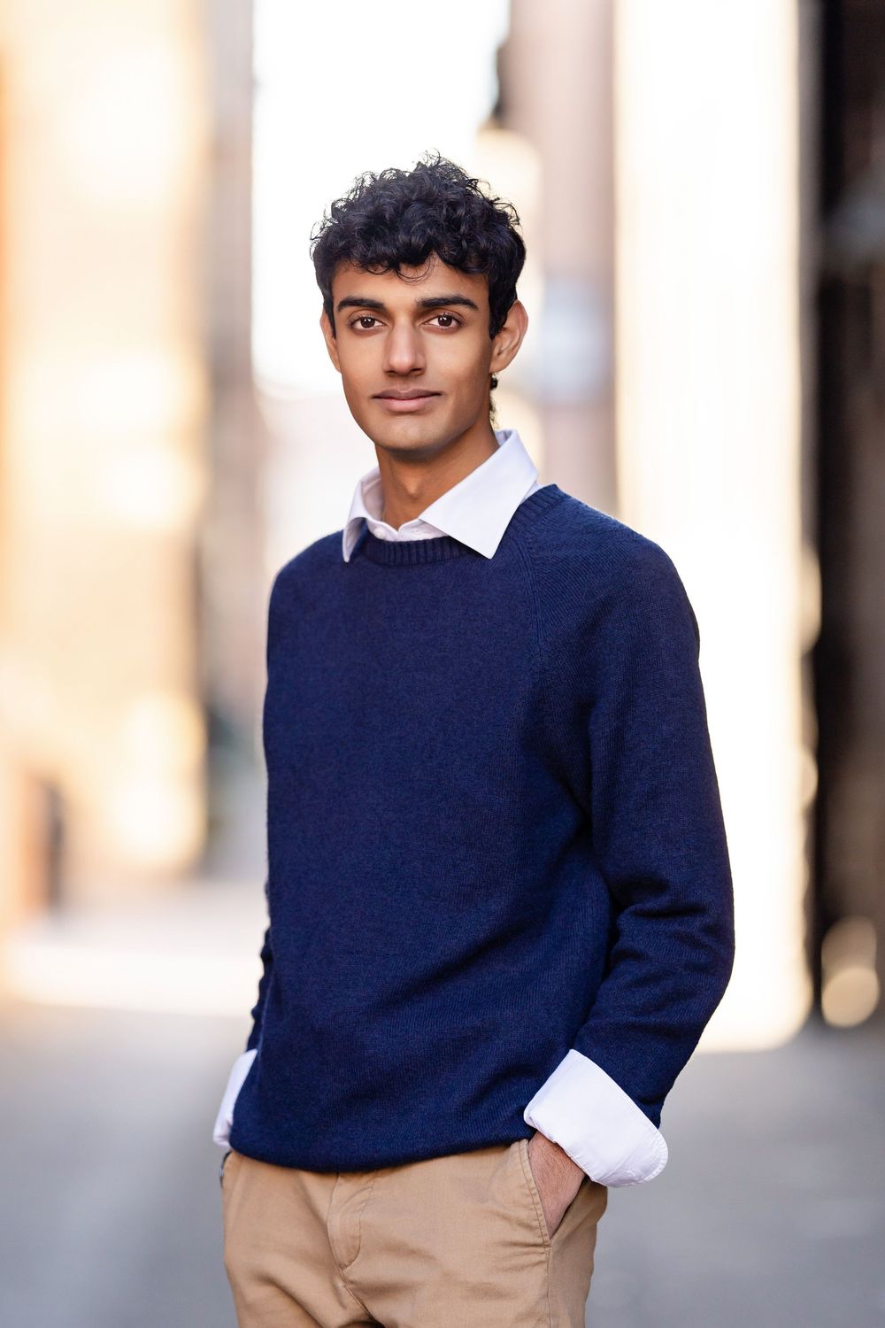 Senior photo of a boy standing in an alley with his hands in his pockets taken by Milwaukee senior photographer Rachel Dickman.
