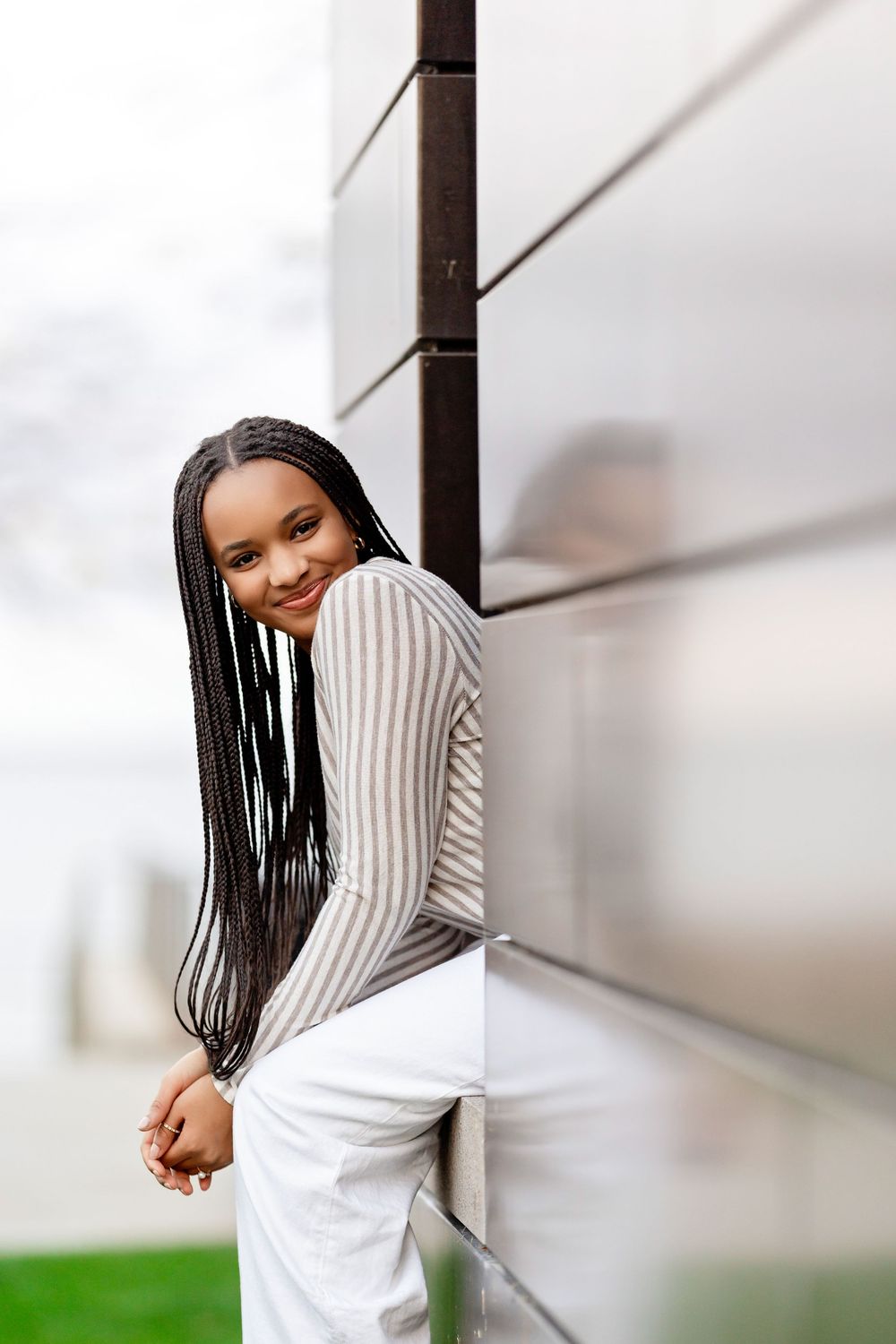 Senior photo of a girl leaning out of a building and looking at the camera taken by Milwaukee senior photographer Rachel Dickman.
