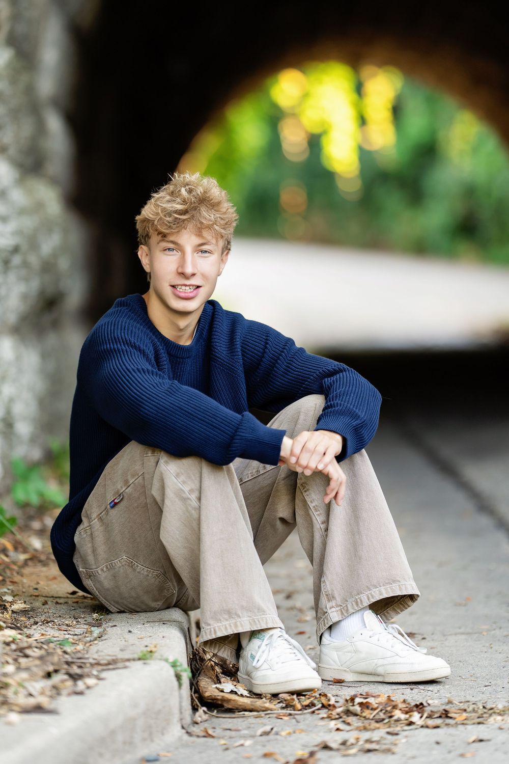 Senior photo of a boy sitting in front of a tunnel taken by Milwaukee senior photographer Rachel Dickman.