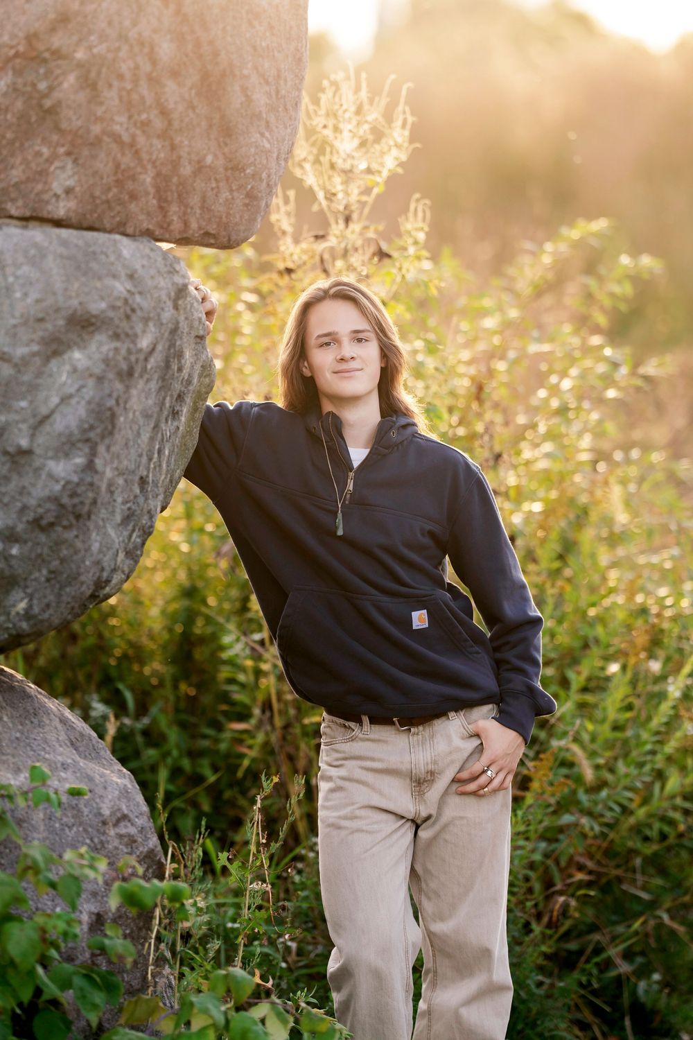 Senior photo of a boy leaning on a stone arch with the sunset behind him taken by Milwaukee senior photographer Rachel Dickman.