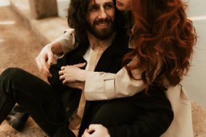 Couple in casual attire sharing an intimate moment outdoors in warm sepia tones.