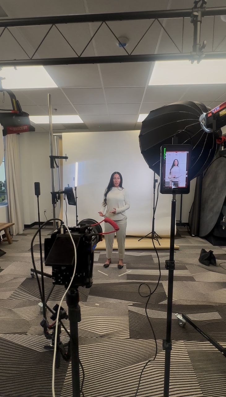 Professional photography studio setup showing lighting equipment, softboxes and camera gear during a fashion photoshoot.