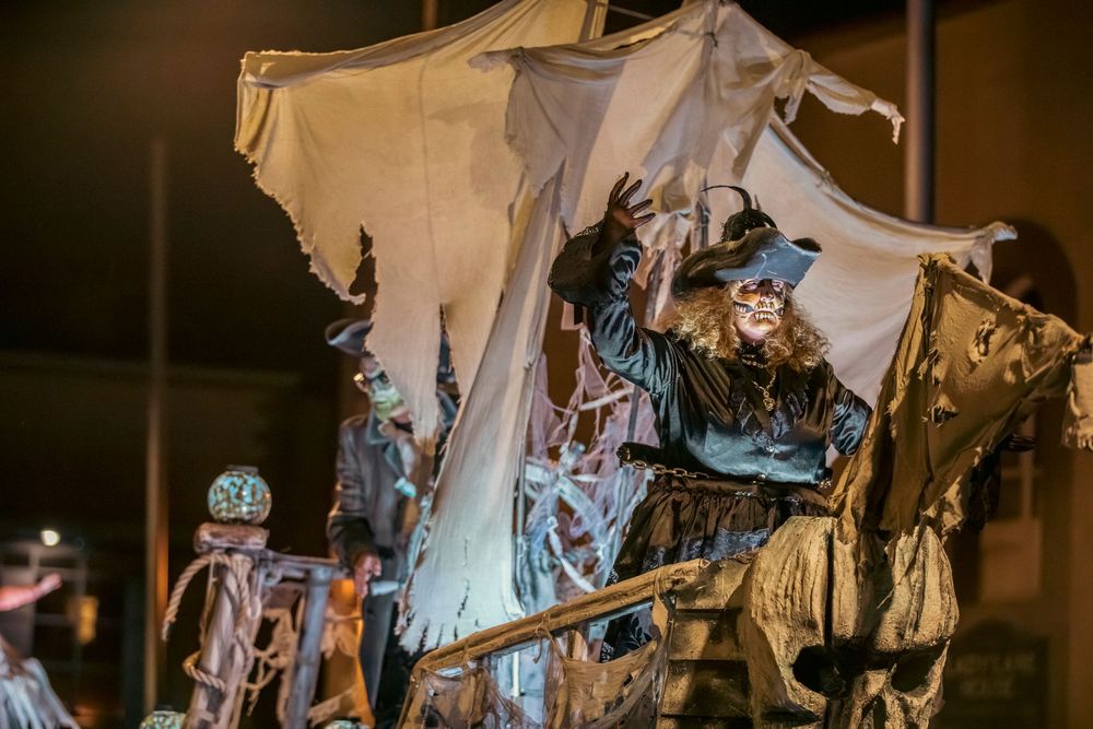 Spooky Halloween decorations with white fabric draping and dark silhouettes create an eerie haunted house atmosphere.