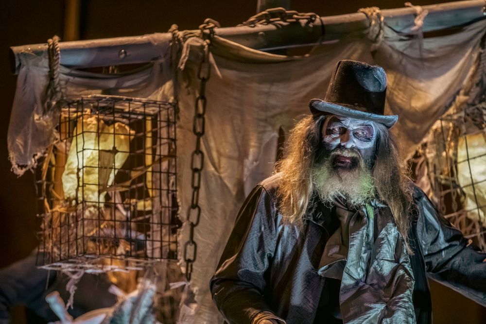 A spooky haunted house scene with chains and tattered fabric decorations in eerie yellow lighting.