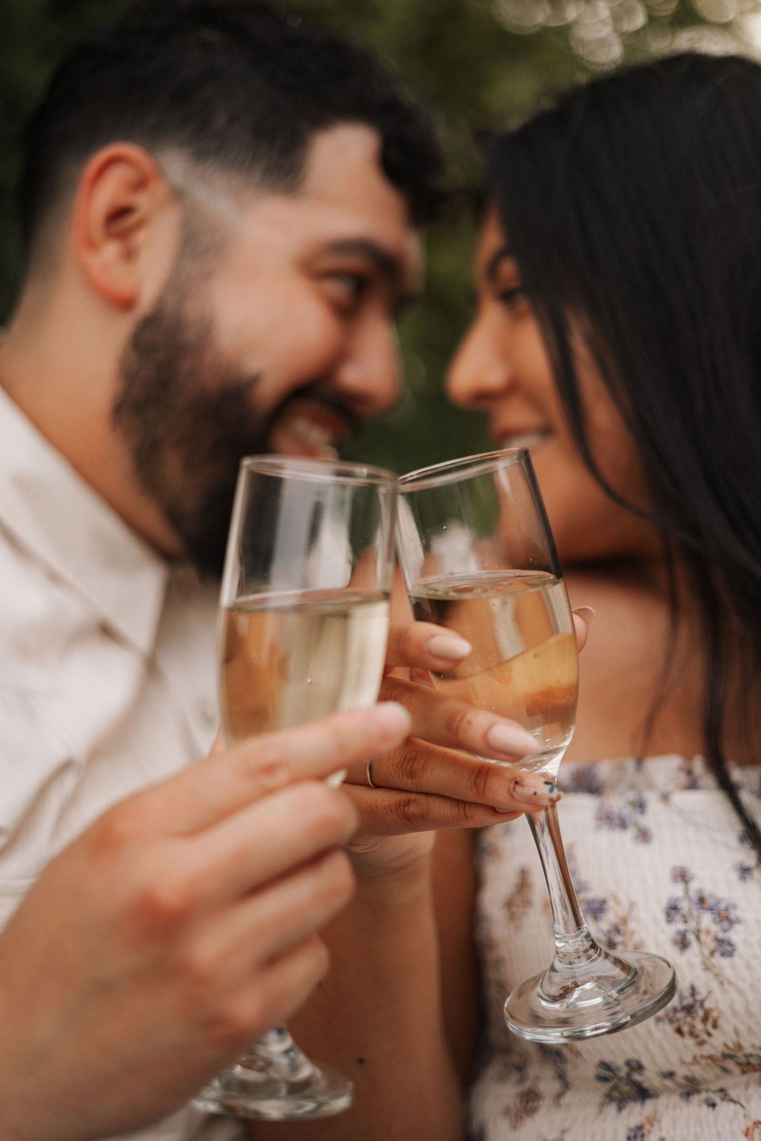 A couple shares an intimate moment while holding wine glasses in a series of romantic candid shots.