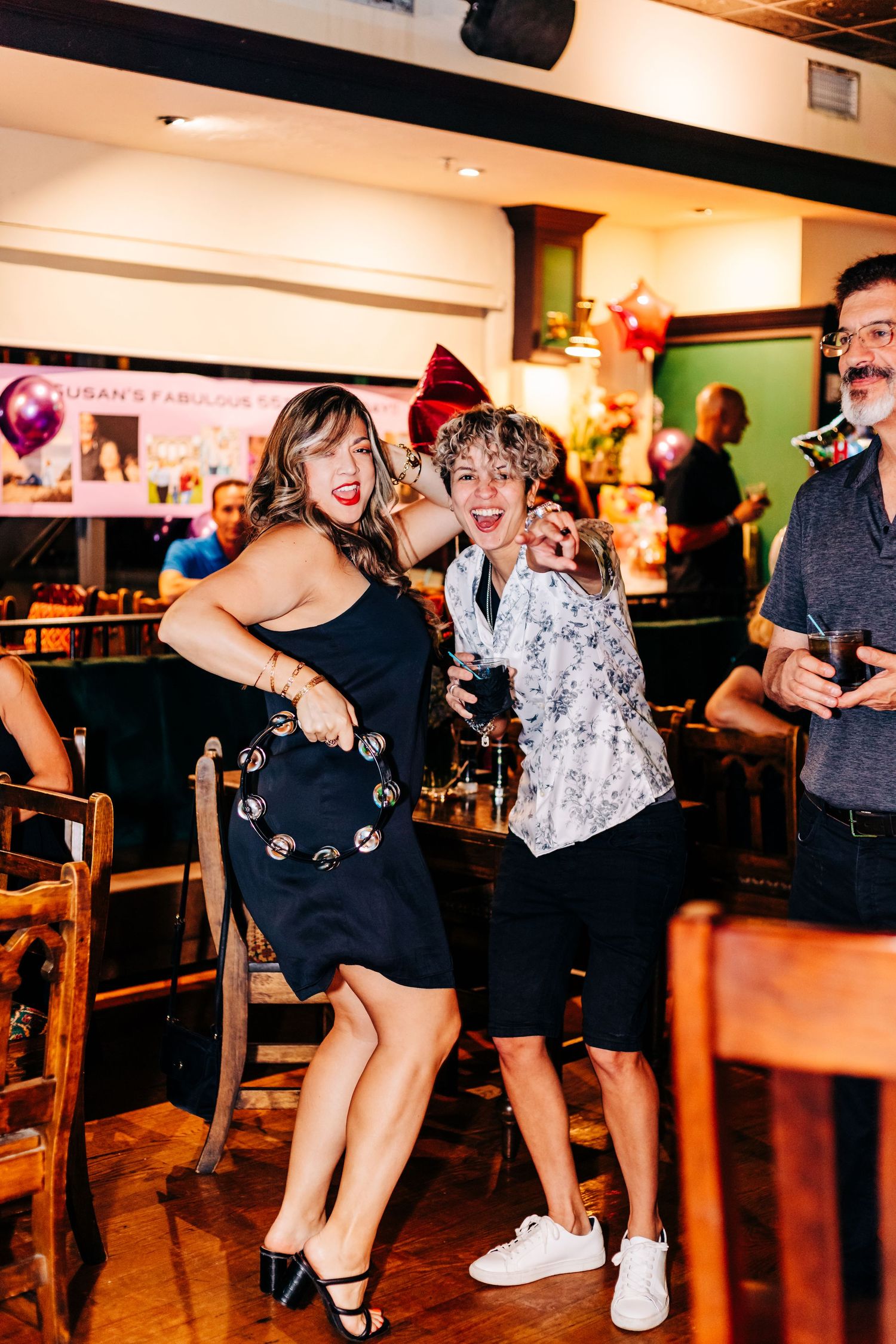 Two people dancing and laughing at indoor party with festive decorations at an event in lake worth.