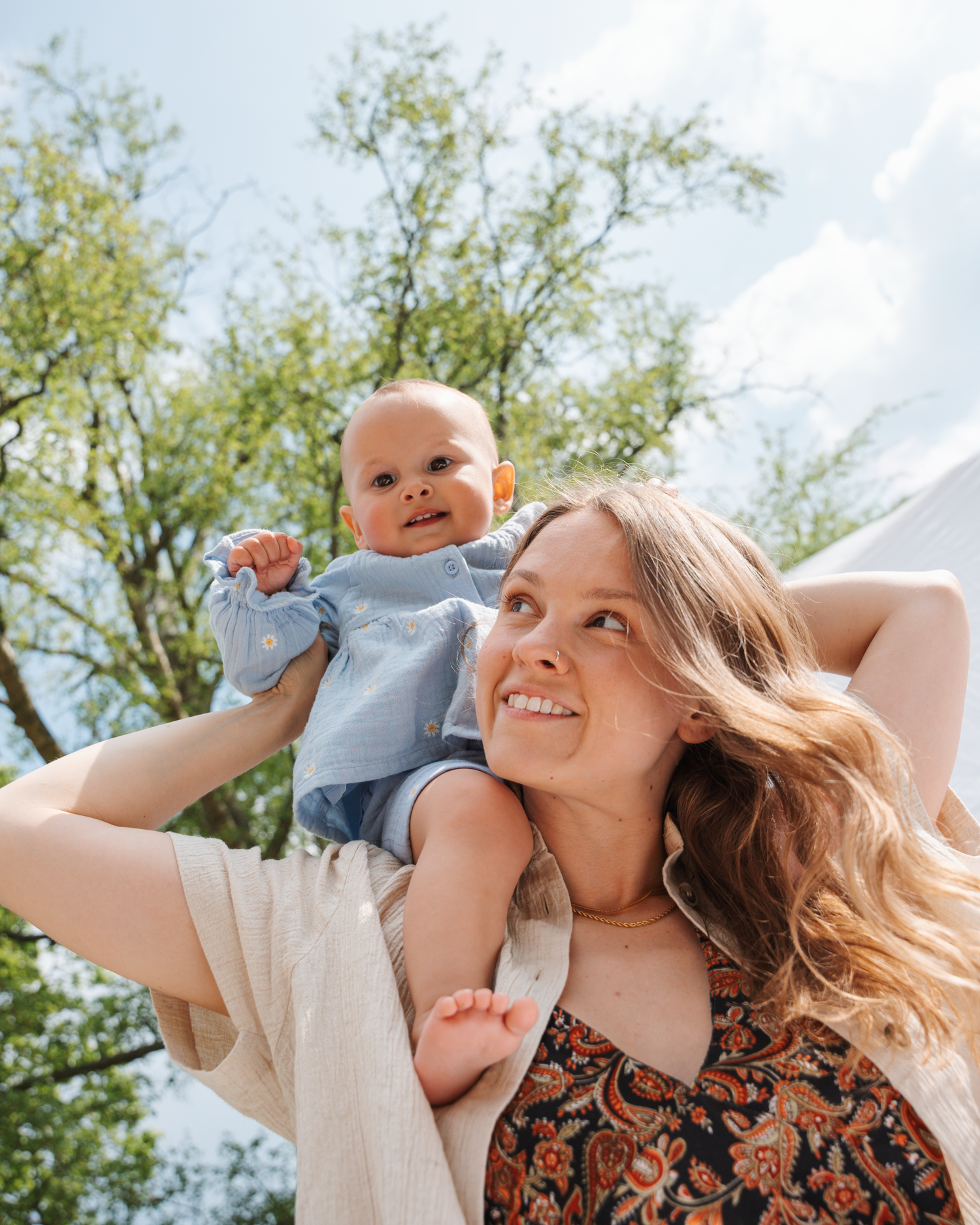 Sunny outdoor portrait with trees in background on bright summer day.