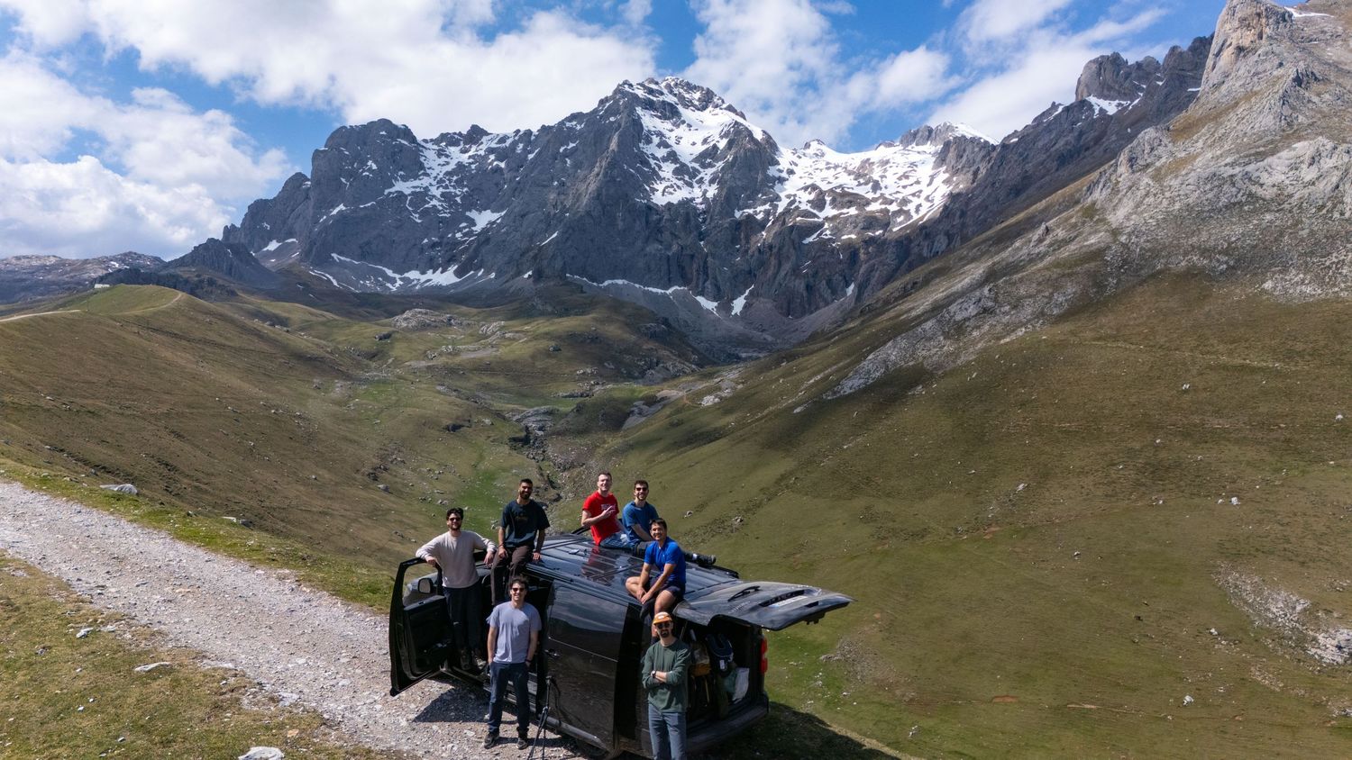 Panoramic mountain landscape with snow-capped peaks and green valley.