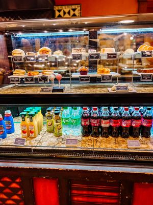 Display case filled with sandwiches and cold beverages in a quick-service restaurant.