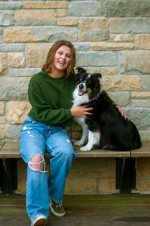 A senior girl laughing with her dog