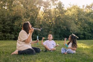 Family relaxes together on grass during golden hour photo session.