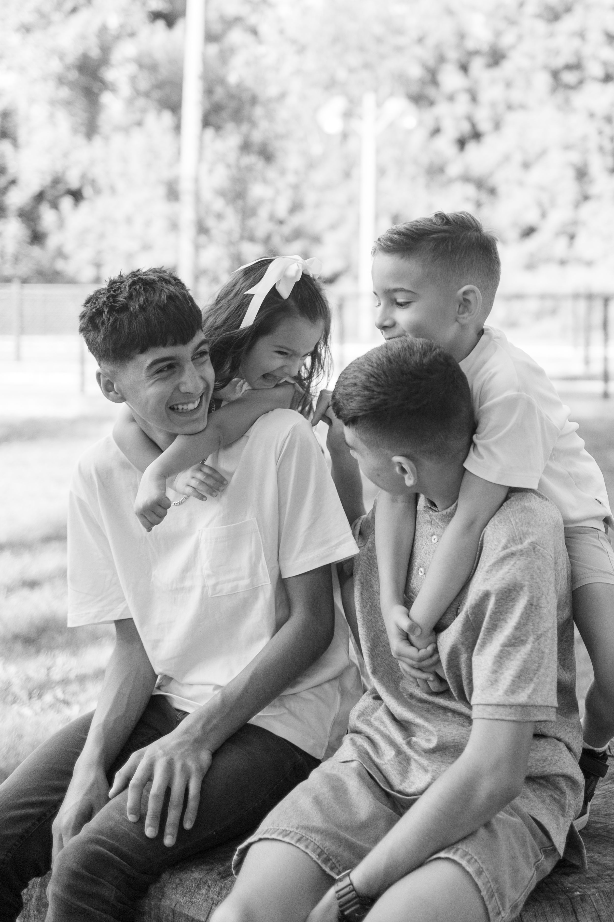 Black and white portrait of family sharing joyful laughter outdoors in Oakville, Canada.