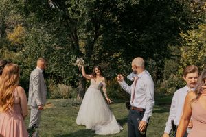 Wedding party celebrates outdoors with joyful expressions.