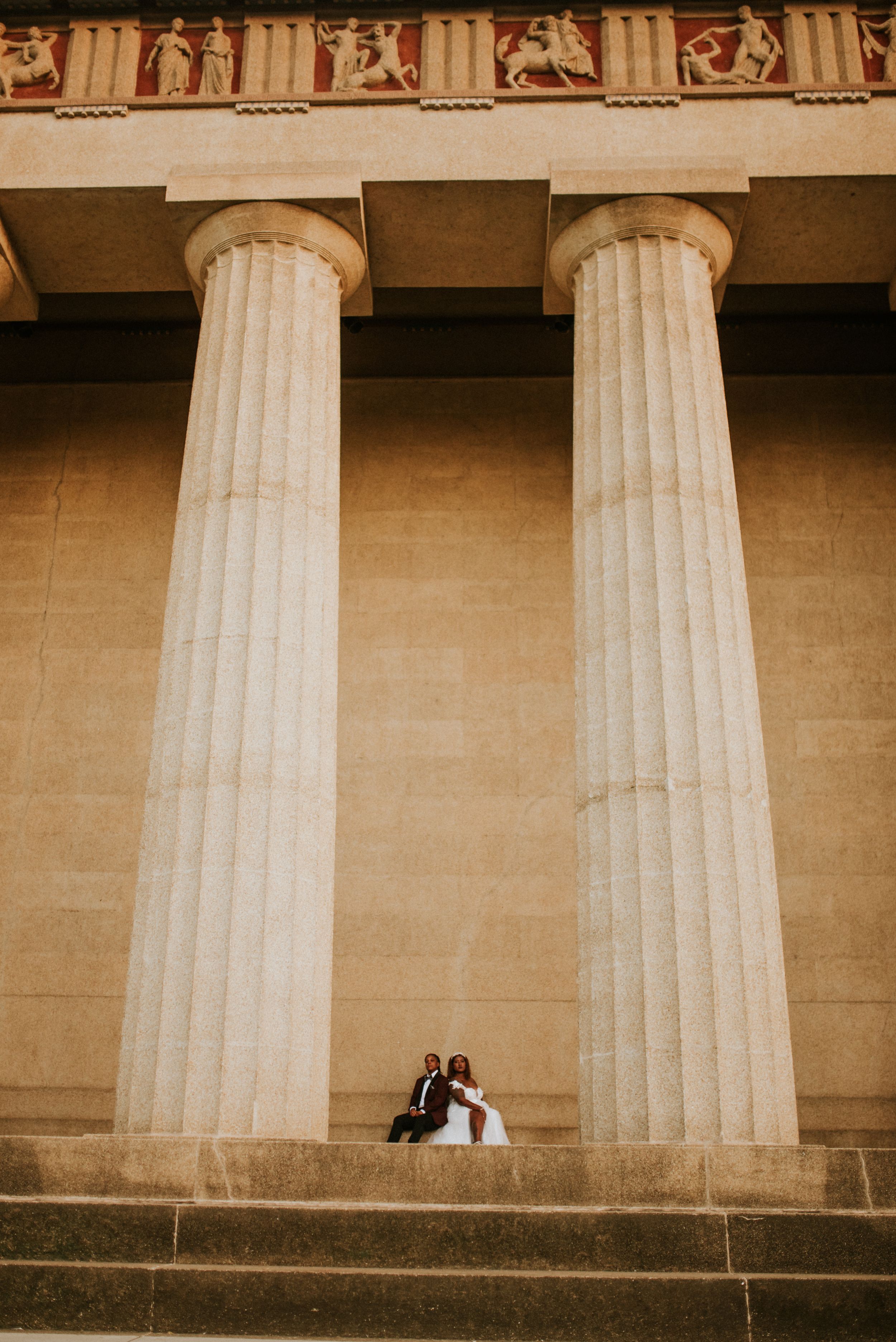 A same sex couple dressed in wedding attire at the parthenon in Nashville, Tennessee.