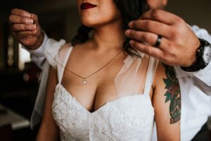 Father's hands putting on a necklace for the bride as she gets ready for her elopement in Las Vegas, Nevada.