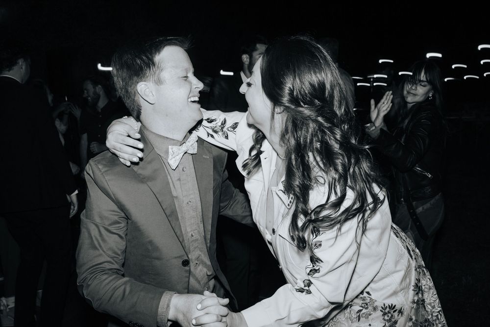 Candid black and white photo of a celebratory moment at a wedding reception.
