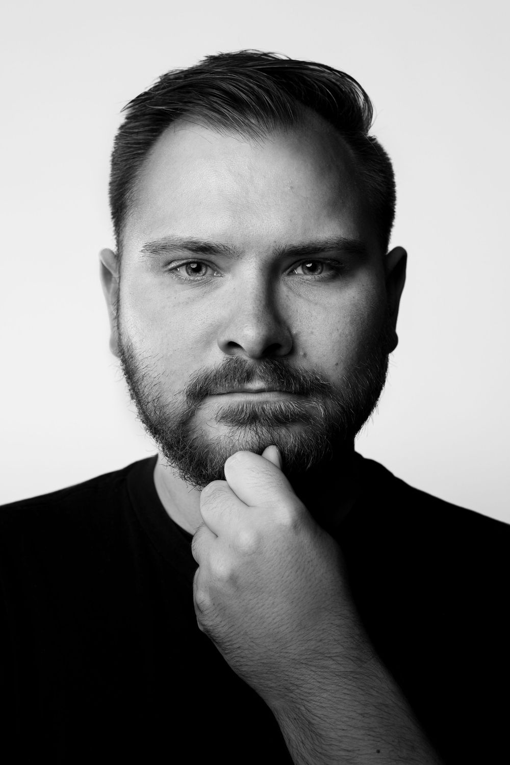 A dramatic black and white portrait series showing a person covering their mouth with their hand in different poses.
