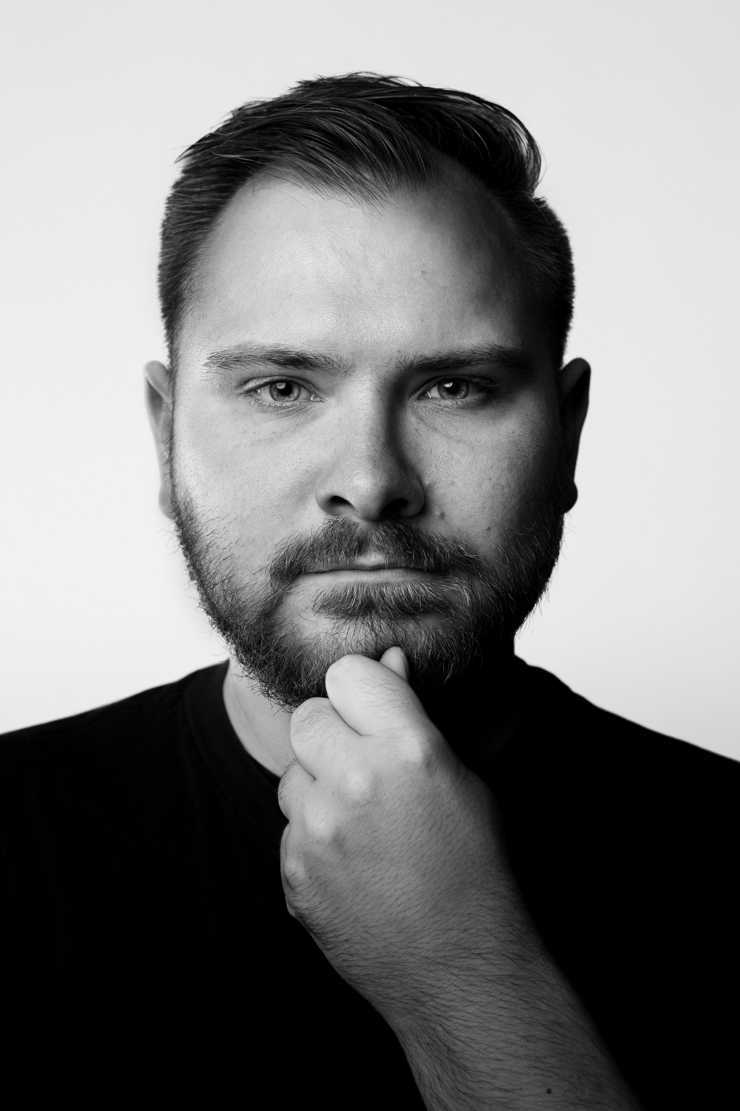 A dramatic black and white portrait series showing a person covering their mouth with their hand in different poses.