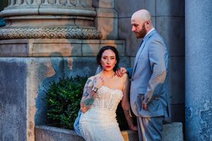 Bride and groom share romantic moments in front of historic stone architecture during their wedding photo session.