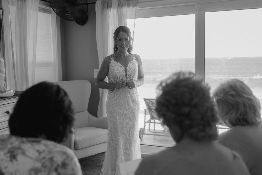 Wedding dress silhouette against bright windows in an elegant indoor setting.