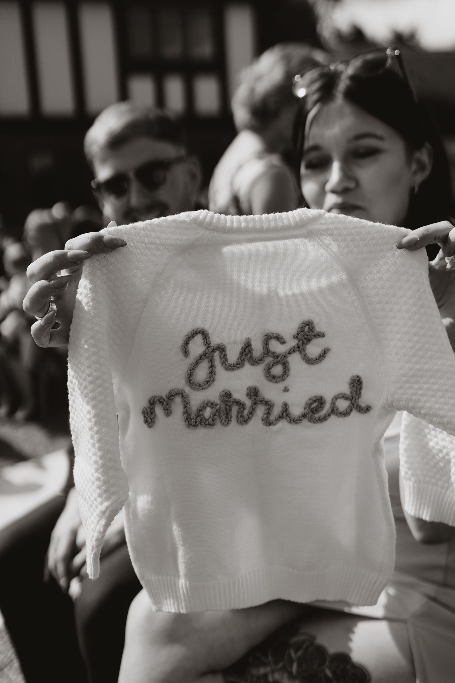 Toddler cardigan display embroidered text that spells out 'Just Married' in a wedding celebration setting.