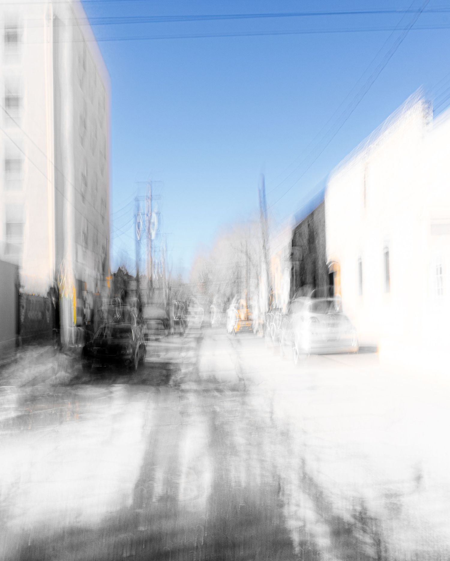 Abstract urban landscape with white buildings blurred against blue sky.