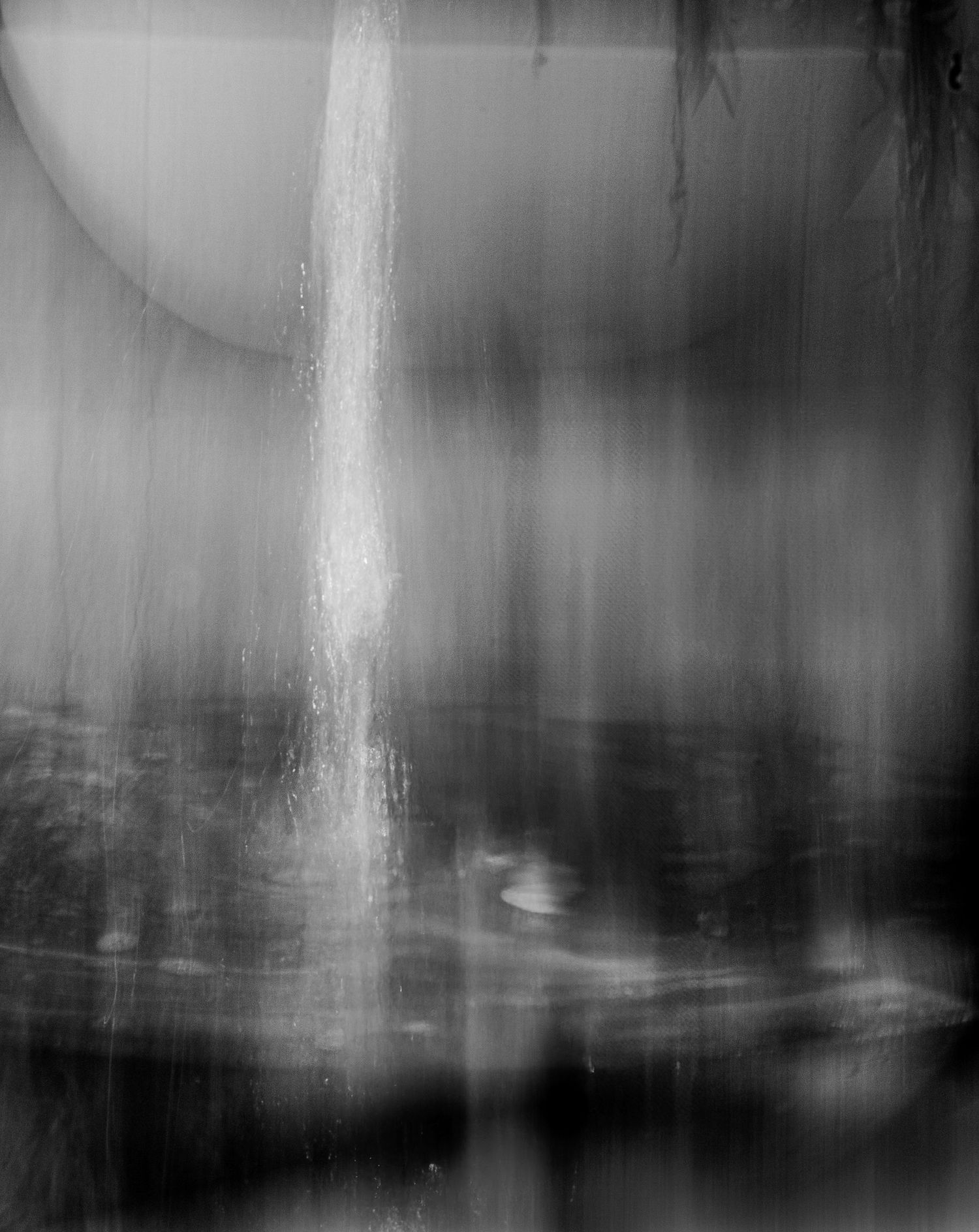 Abstract dark composition with vertical light streaks in grayscale.