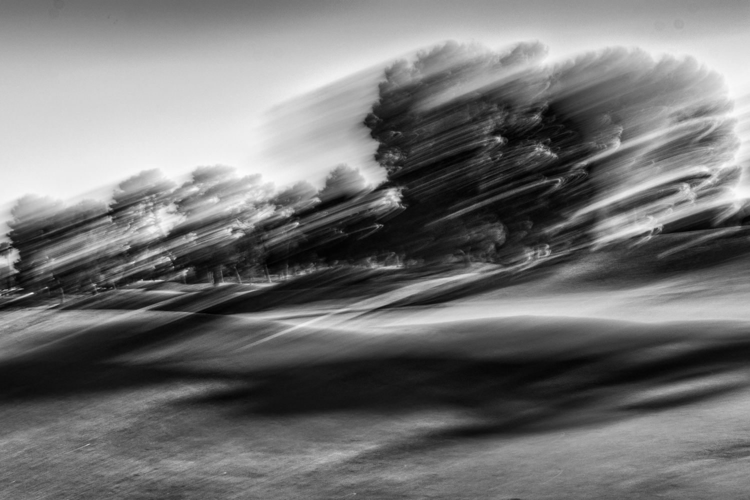 Minimalist black and white horizon with sweeping cloud formations.