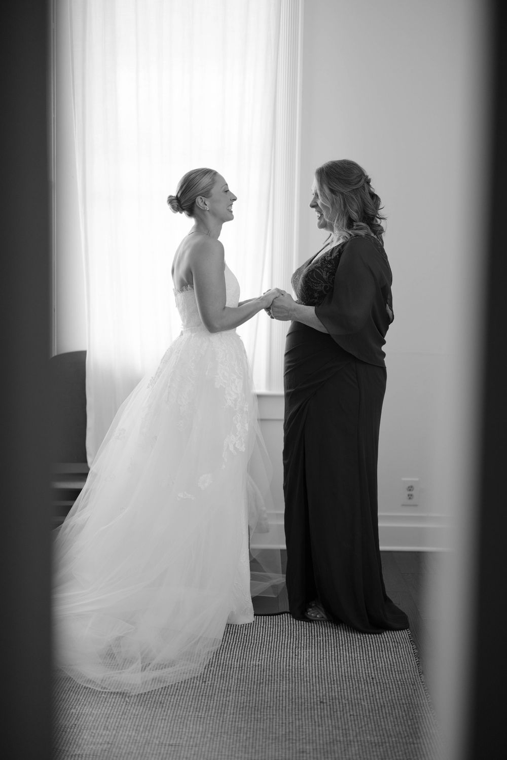A series of black and white photos showing intimate moments before a wedding as a bride is helped with preparations.