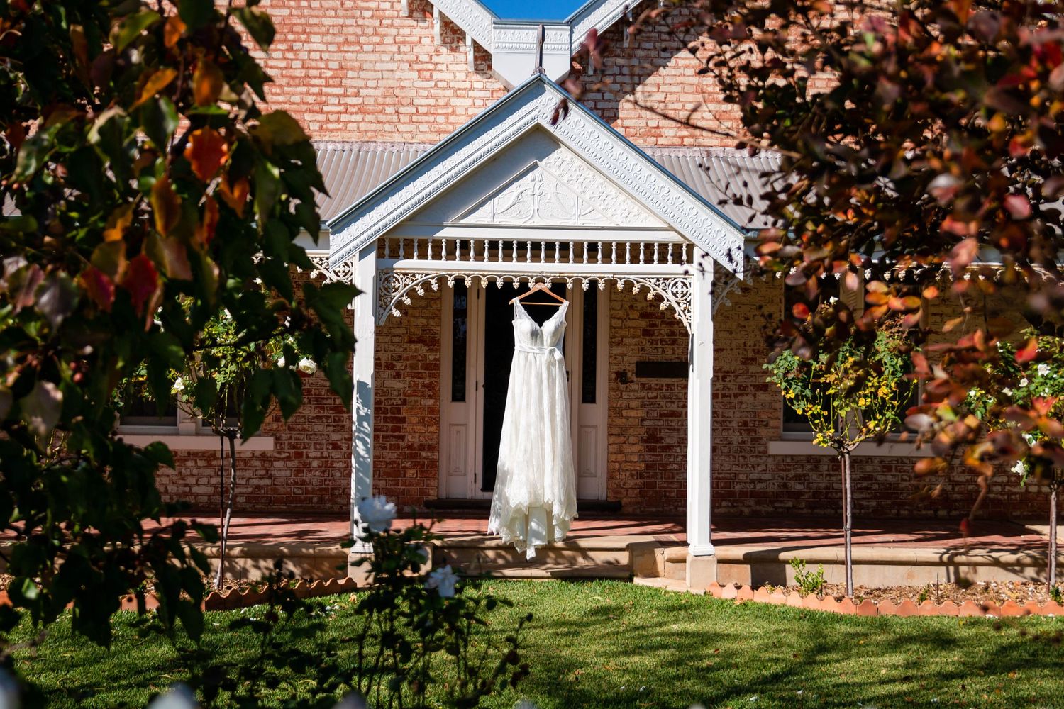 Classic brick chapel with white trim and decorative elements surrounded by autumn foliage.