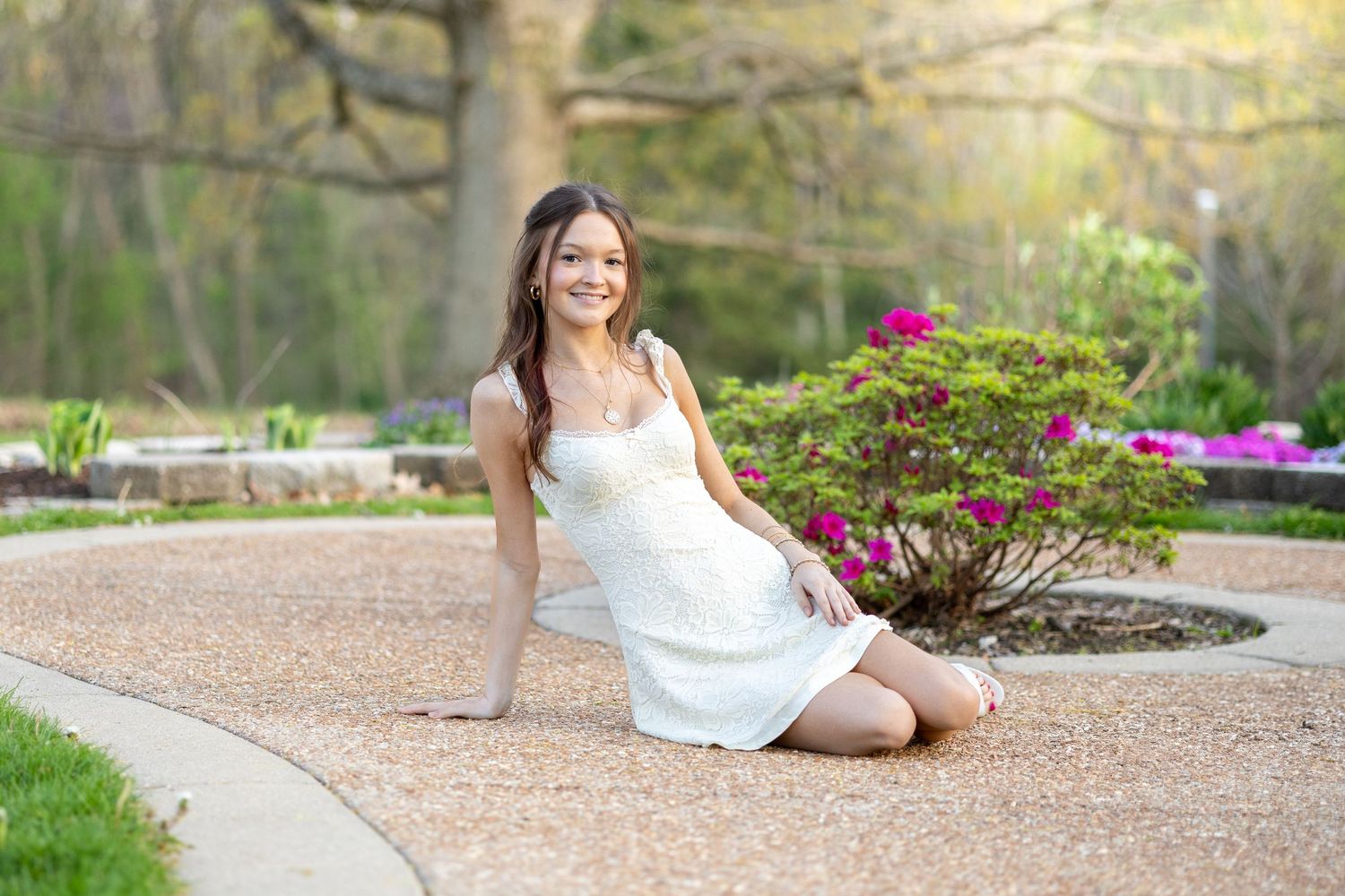 Springfield, IL senior photographer captures a senior smiling next to flowers during a session in Central, IL