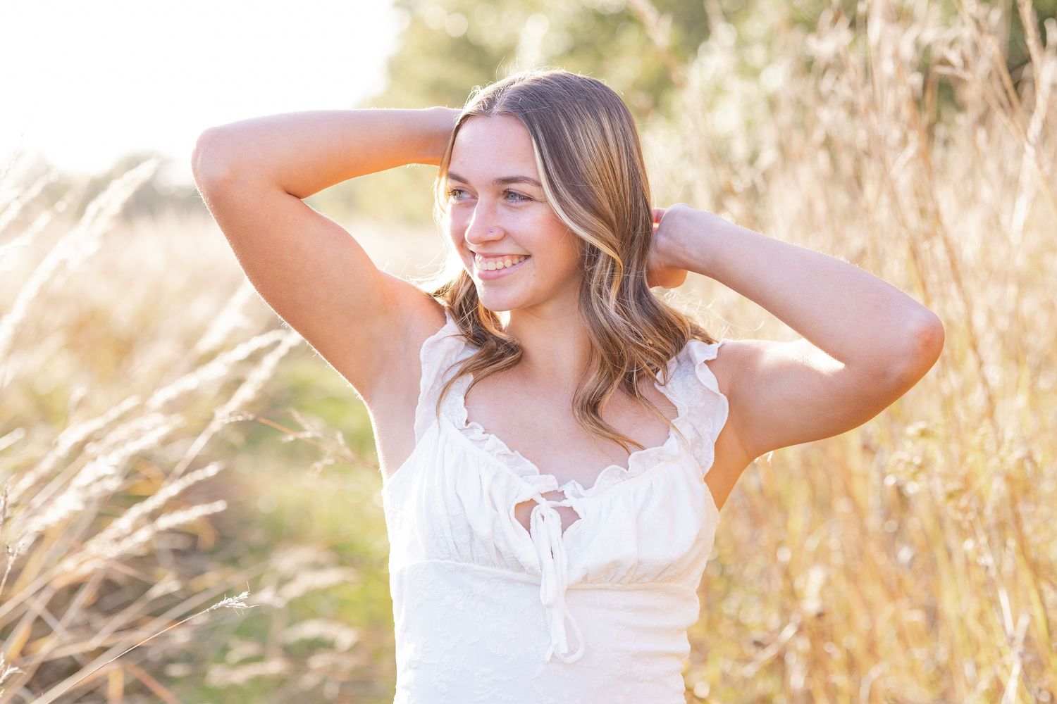 Springfield, IL senior photographer captures a senior looking to the side surrounded by tall native grass during a session in Central, IL