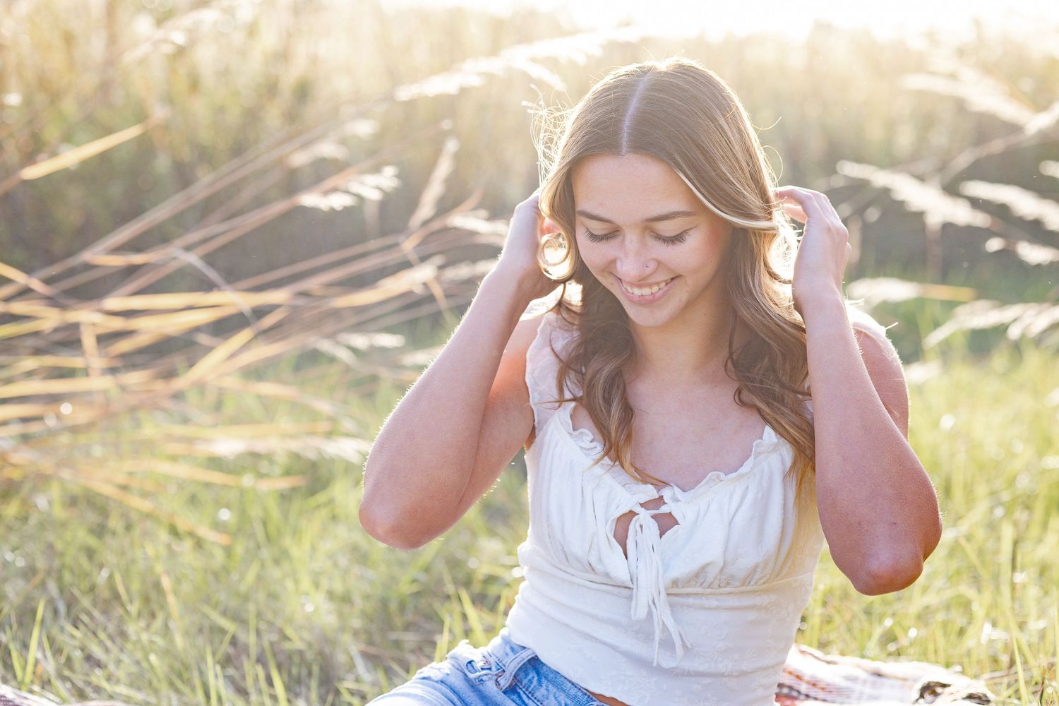 Springfield, IL senior photographer captures a senior looking down and playing with her hair during a session in Central, IL