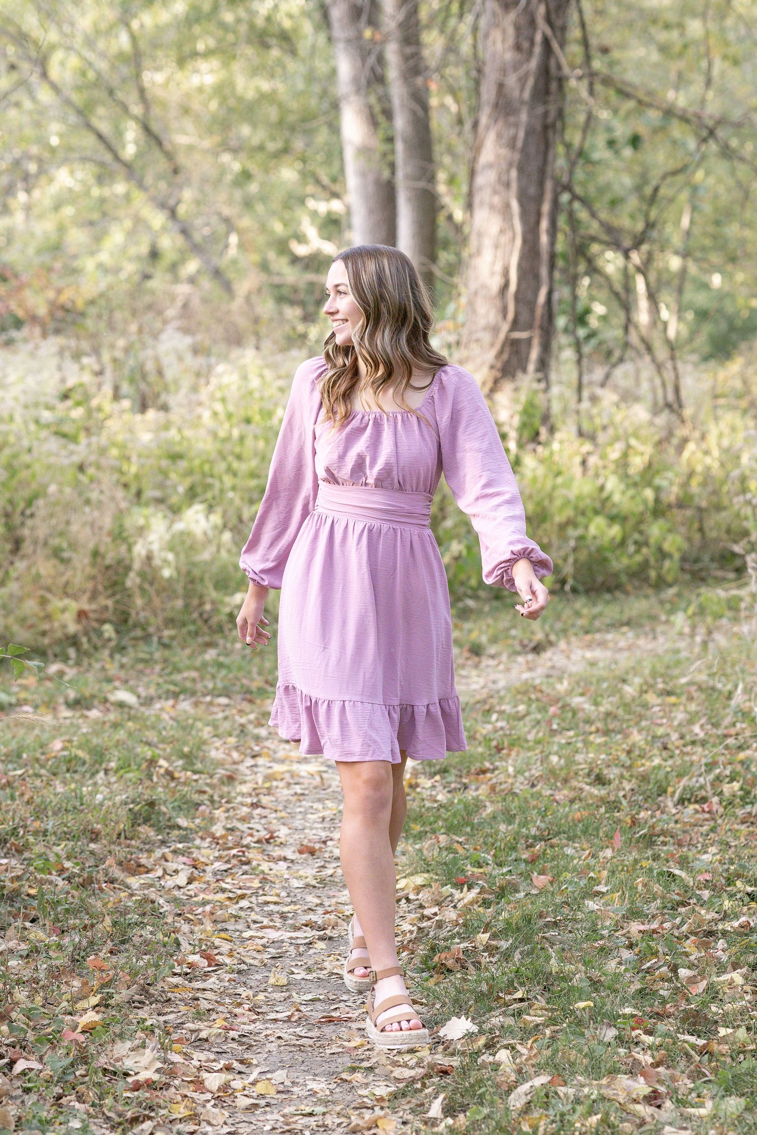 Springfield, IL senior photographer captures a senior walking on a trail during a session in Central, IL