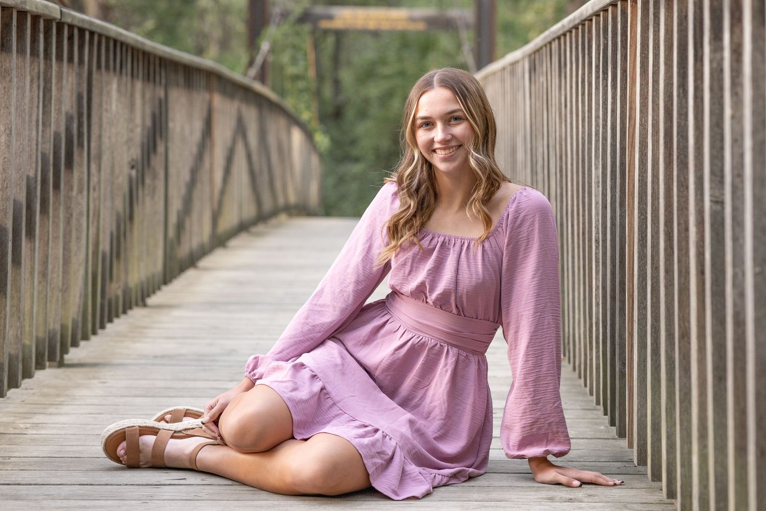 Springfield, IL senior photographer captures  a senior sitting on a bridge during a session in Central, IL
